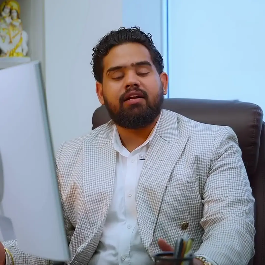 Nitin Sharma at his desk in a light suit