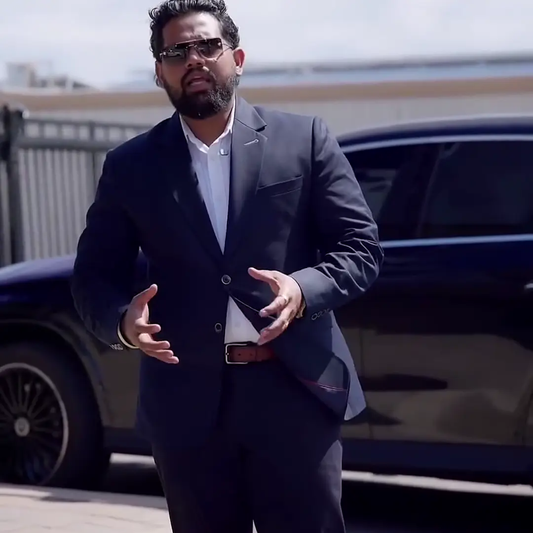 Nitin Sharma standing in a parking lot in a dark suit